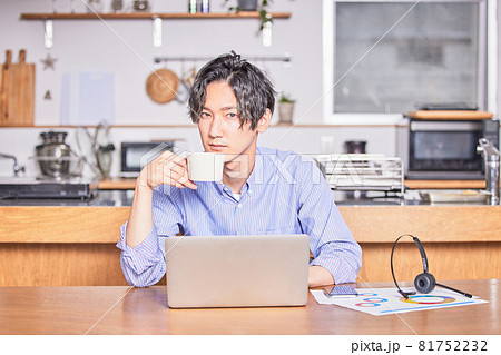 テレワーク中に気分転換にコーヒーを飲む若い男性 81752232