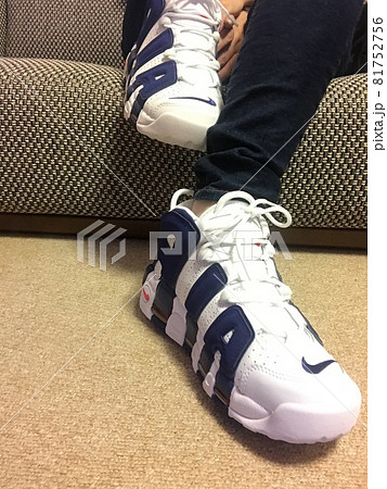 ソファに座ってスニーカーを履く女性 81752756