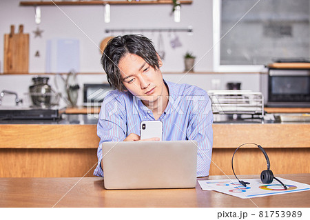 テレワーク中に集中が切れてネットサーフィンする若い男性 81753989