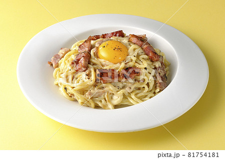 カリカリに焼いた厚切りベーコン入りのカルボナーラに卵黄トッピング 81754181