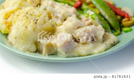Tender pieces of smoked haddock and pollock in a creamy cheese sauce sat beneath buttery mash served with vegetables Tender pieces of smoked haddock and pollock in a creamy cheese sauce sat beneath buttery mash served with vegetables 81761631