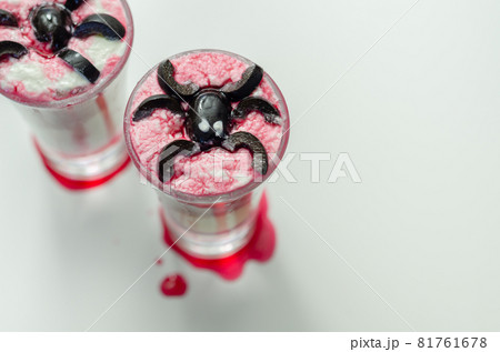 Drinks shots prepared by the bartender at the Halloween party decorated with black olives in the shape of spiders Drinks shots prepared by the bartender at the Halloween party decorated with black olives in the shape of spiders 81761678