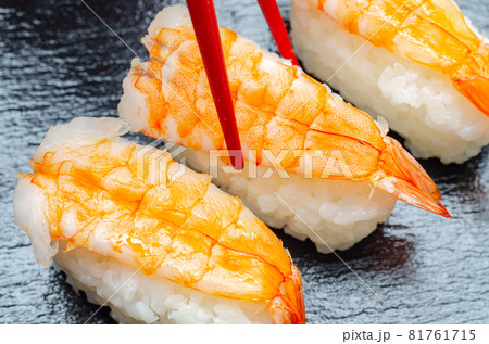 Closeup of ebi king prawn nigiri prepared by a Japanese chef in a restaurant Closeup of ebi king prawn nigiri prepared by a Japanese chef in a restaurant 81761715