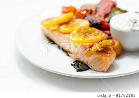 Grilled salmon fillet served with roasted vegetables with cucumber and dill sauce Grilled salmon fillet served with roasted vegetables with cucumber and dill sauce 81762185