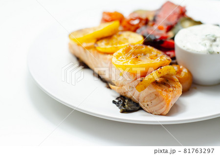 Grilled salmon fillet served with roasted vegetables with cucumber and dill sauce Grilled salmon fillet served with roasted vegetables with cucumber and dill sauce 81763297