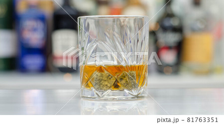 Old fashioned glass with scotch whisky and ice cubes on the bar Old fashioned glass with scotch whisky and ice cubes on the bar 81763351