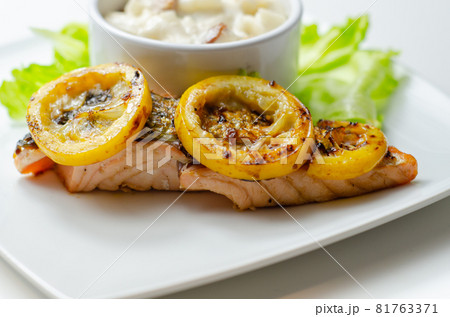 Grilled salmon fillet served with an exquisite salad consisting of cabbage, celery and apple with sultanas and roasted peanuts in mayonnaise Grilled salmon fillet served with an exquisite salad consisting of cabbage, celery and apple with sultanas and roasted peanuts in mayonnaise 81763371