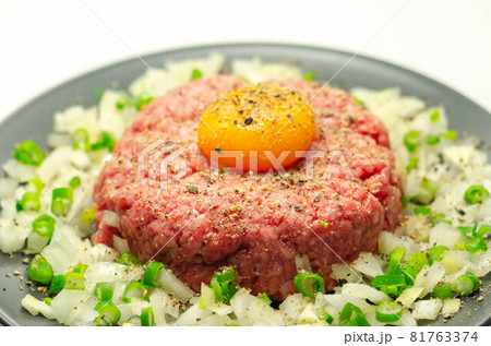 Beef steak tartare with raw egg yolk and onion with chive 81763374