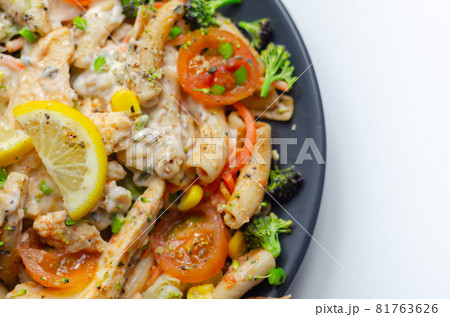 Piri piri style chicken on a bed of wholewheat pasta and vegetables, with a cool sour cream and chive dressing 81763626