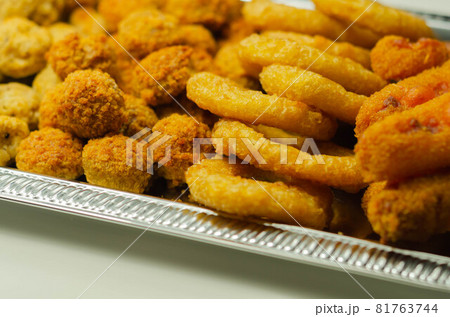 Southern fried and roast chicken bites, onion rings and mozzarella stick served on the silver tray 81763744