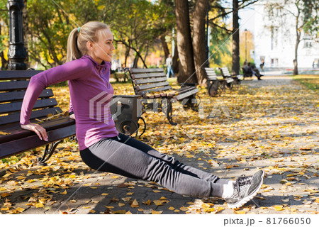 Young woman does push-up exercises in the park. Sports outside in autumn 81766050