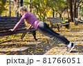 Young woman does push-up exercises in the park. Sports outside in autumn 81766051