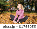 Young woman is doing sports outside in a autumn park 81766055