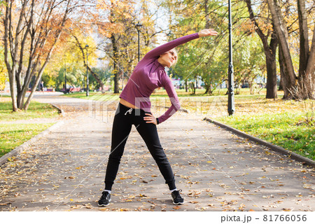 Young woman does exercises in the park. Sports outside in autumn 81766056