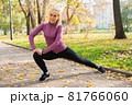Young woman does stretching exercises in the park. Sports outside in autumn 81766060