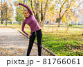 Young woman does exercises in the park. Sports outside in autumn 81766061