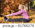 Young woman does stretching exercises in the park. Sports outside in autumn 81766276