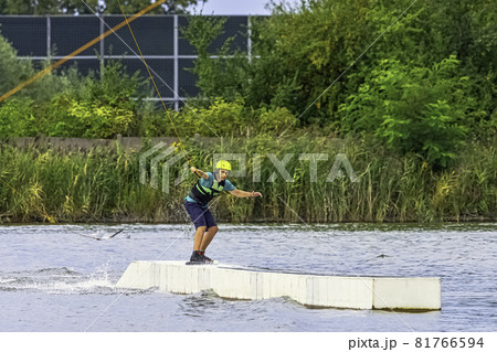 Teenager wakeboarding on a lake - Brwinow, Masovia, Poland Teenager wakeboarding on a lake - Brwinow, Masovia, Poland 81766594