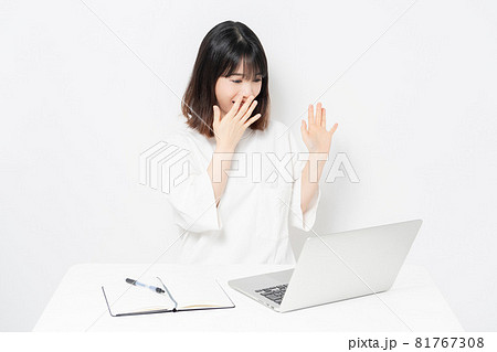 ノートパソコンを使いながらビックリして驚いている若い女性 ノートパソコンを使いながらビックリして驚いている若い女性 81767308