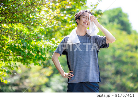 外で運動後に汗を拭う男性 81767411