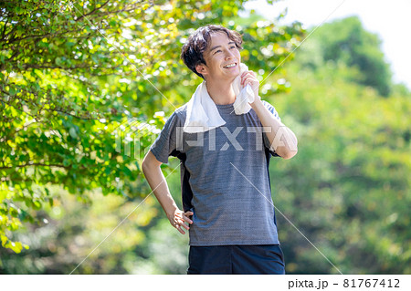 外で運動後に汗を拭う男性 外で運動後に汗を拭う男性 81767412