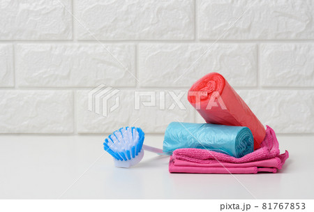 brush and stack of disposable plastic trash can bags 81767853