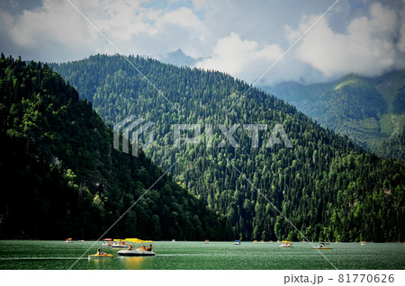 Catamarans on Lake Ritsa in Abkhazia. Walks on the water. Ecologically clean place in the mountains. 81770626