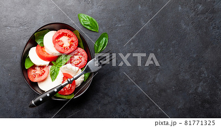 Caprese salad with fresh tomatoes, garden basil and mozzarella cheese Caprese salad with fresh tomatoes, garden basil and mozzarella cheese 81771325