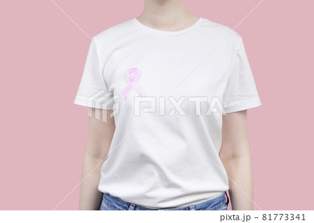 World Breast cancer day concept. Woman in white T-shirt holds pink ribbon in her hand. October Breast Cancer Awareness month 81773341