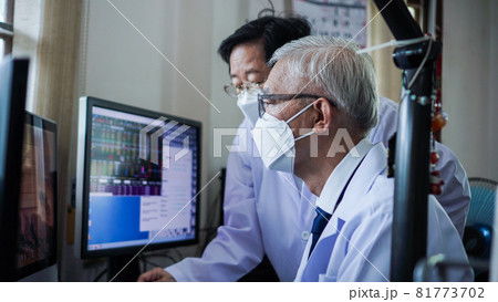 Asian senior elder doctors wearing mask looking at computer screen diagnose patient data and information Asian senior elder doctors wearing mask looking at computer screen diagnose patient data and information 81773702