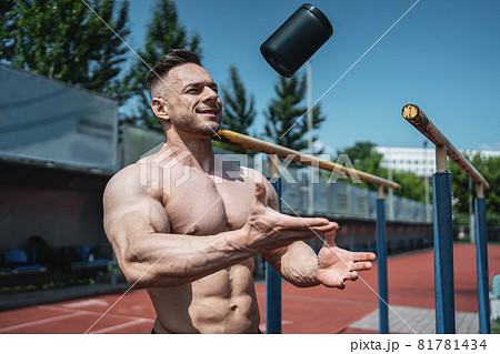 muscular athlete man throw up black container with protein whey powder outdoor muscular athlete man throw up black container with protein whey powder outdoor 81781434