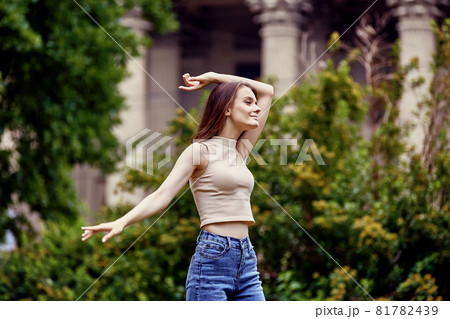 Slender Caucasian woman, 18 years, in front of colonnade of historic building in European city. Slender Caucasian woman, 18 years, in front of colonnade of historic building in European city. 81782439