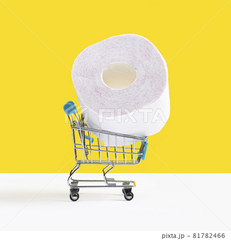 Toy shopping cart or trolley with large roll of toilet paper isolated on yellow background. Sale concept. Toy shopping cart or trolley with large roll of toilet paper isolated on yellow background. Sale concept. 81782466