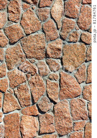 The texture of the wall is lined with red granite stones in the sunlight. The texture of the wall is lined with red granite stones in the sunlight. 81784761