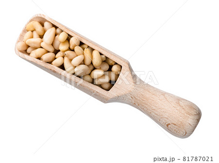 top view of peeled pine nuts in wooden scoop cutout on white background 81787021