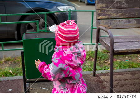 adorable kid throws trash in a street bin 81788784