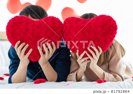 Unrecognizable couple hiding faces behind hearts 81792864