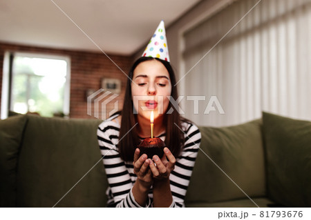 Birthday girl blows out a burning candle on a cupcake Birthday girl blows out a burning candle on a cupcake 81793676