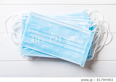 Close up of virus outbreak inscription on stack of medical masks on colored background. Wuhan virus. World epidemic Close up of virus outbreak inscription on stack of medical masks on colored background. Wuhan virus. World epidemic 81794463