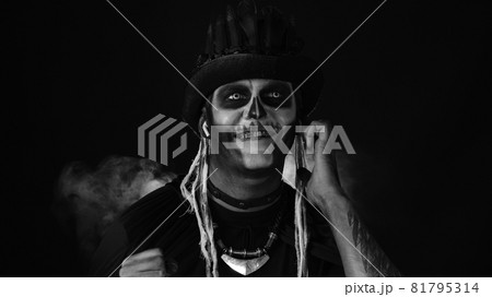 Scary guy in costume of Halloween skeleton wearing earphones, listening music, dancing, celebrating 81795314