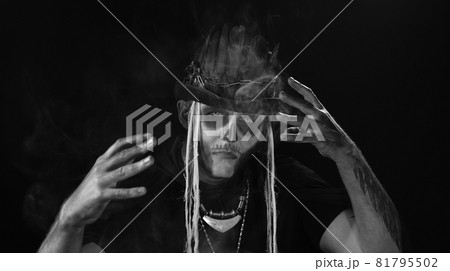 Man in skeleton Halloween cosplay costume. Guy in creepy skull makeup making faces, looks mysterious 81795502