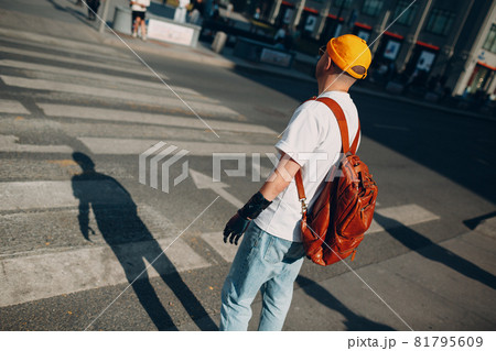 Young disabled man with artificial prosthetic hand in casual clothes and backpack walking at sunny city street outdoor Young disabled man with artificial prosthetic hand in casual clothes and backpack walking at sunny city street outdoor 81795609