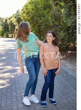 Mother and daughter walking in the park Mother and daughter walking in the park 81795997
