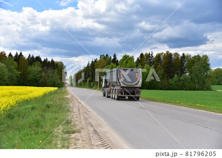 Truck with tipper semi trailer transported sand from the quarry on driving along highway. Truck with tipper semi trailer transported sand from the quarry on driving along highway. 81796205
