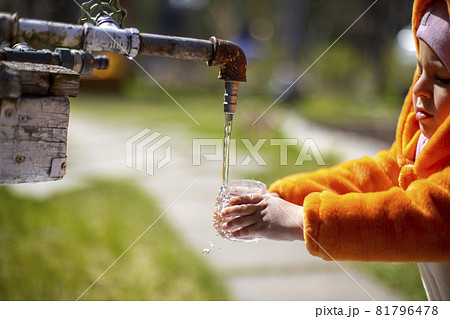 adorable little toddler playing with water in the backyard. child in a fox costume. 81796478