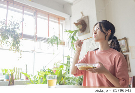 部屋で食事をする若い女性 81796942