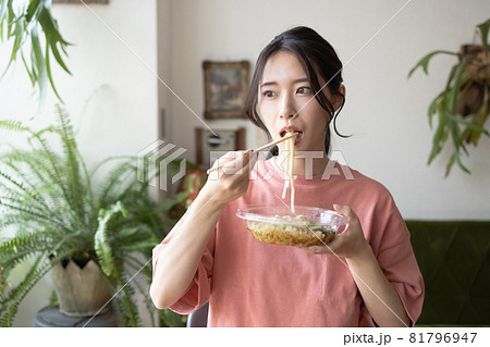 部屋でうどんを食べる若い女性 81796947