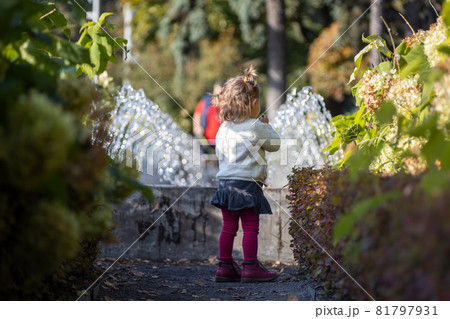 charming toddler in the park with fountains in the background 81797931