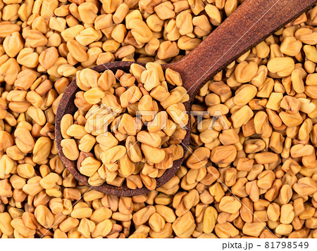 top view of wood spoon on pile of Fenugreek seeds closeup top view of wood spoon on pile of Fenugreek seeds closeup 81798549