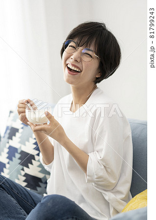 ソファーでヨーグルトを食べる若い女性 ソファーでヨーグルトを食べる若い女性 81799243